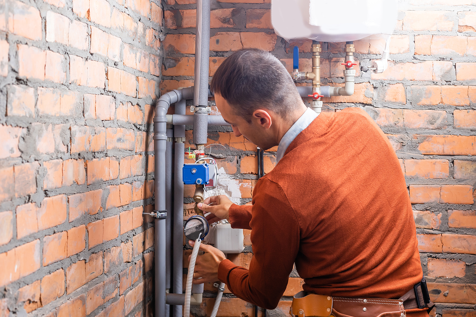 new gas main installation - plumber at boiler room installation